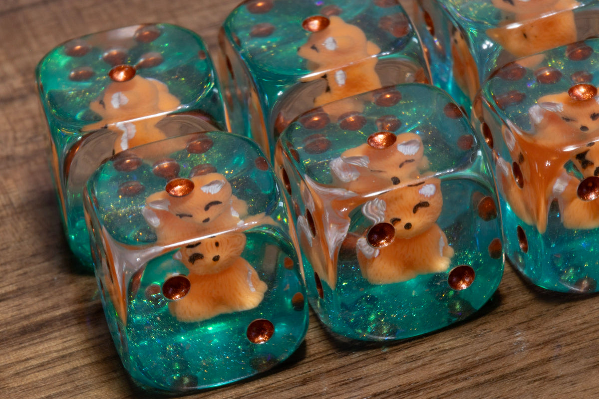 Fox's Cunning PIP D6 dice – fox cub figurines in clear resin on a teal glitter layer
