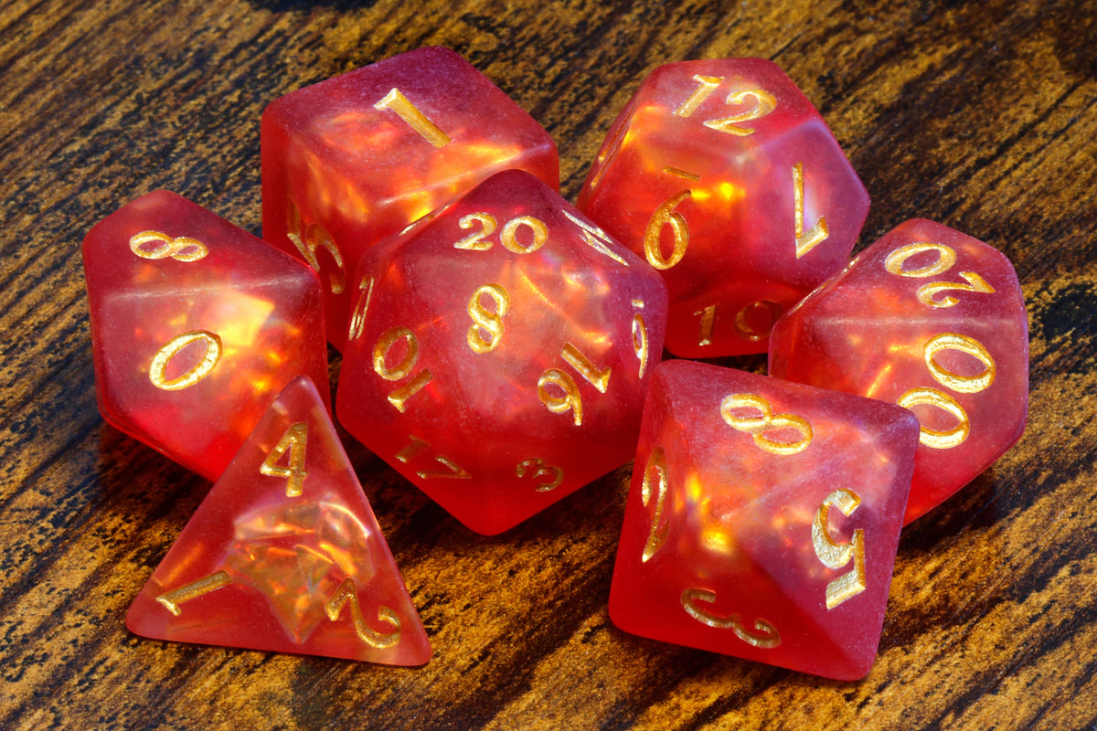 Dragon's Breath 7-piece dice set, red-orange frosted resin with holographic inclusions, the set shown with the Dragon pendant