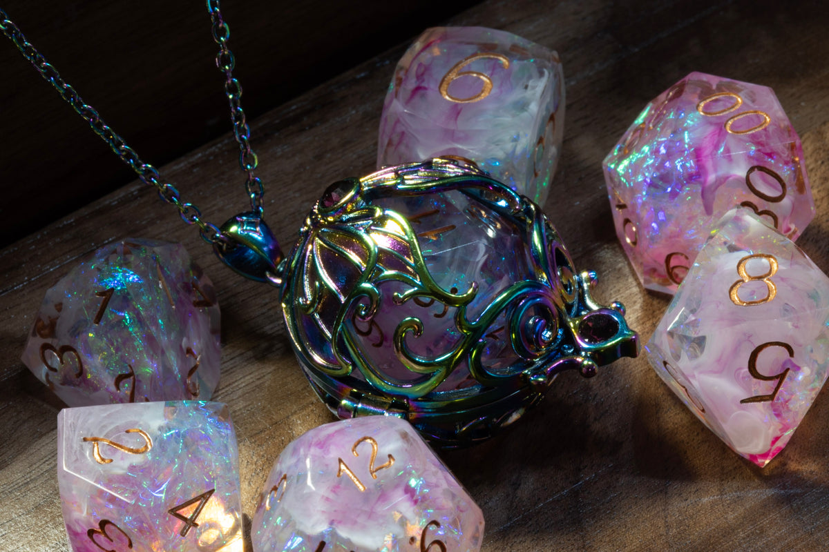 Lunar moth pendant in a rainbow finish with the Blush Opal dice set on wood
