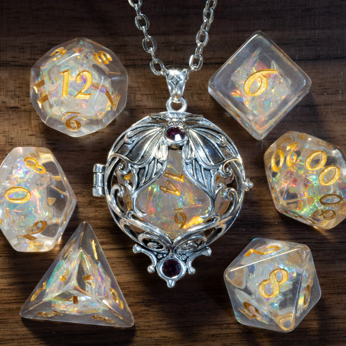 Lunar moth pendant in a silver finish holding a Sacred Opal D20, beside the Sacred Opal dice set on wood