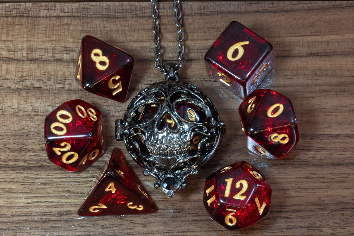 Skull pendant in a black finish with a Cherry Opal dice set on wood