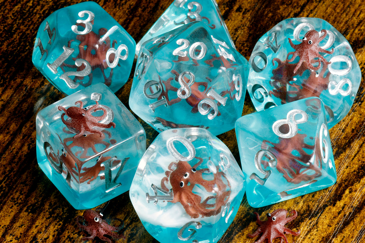 Octopus dice set with miniature octopus inclusions on a blue layer - The Wizard's Vault