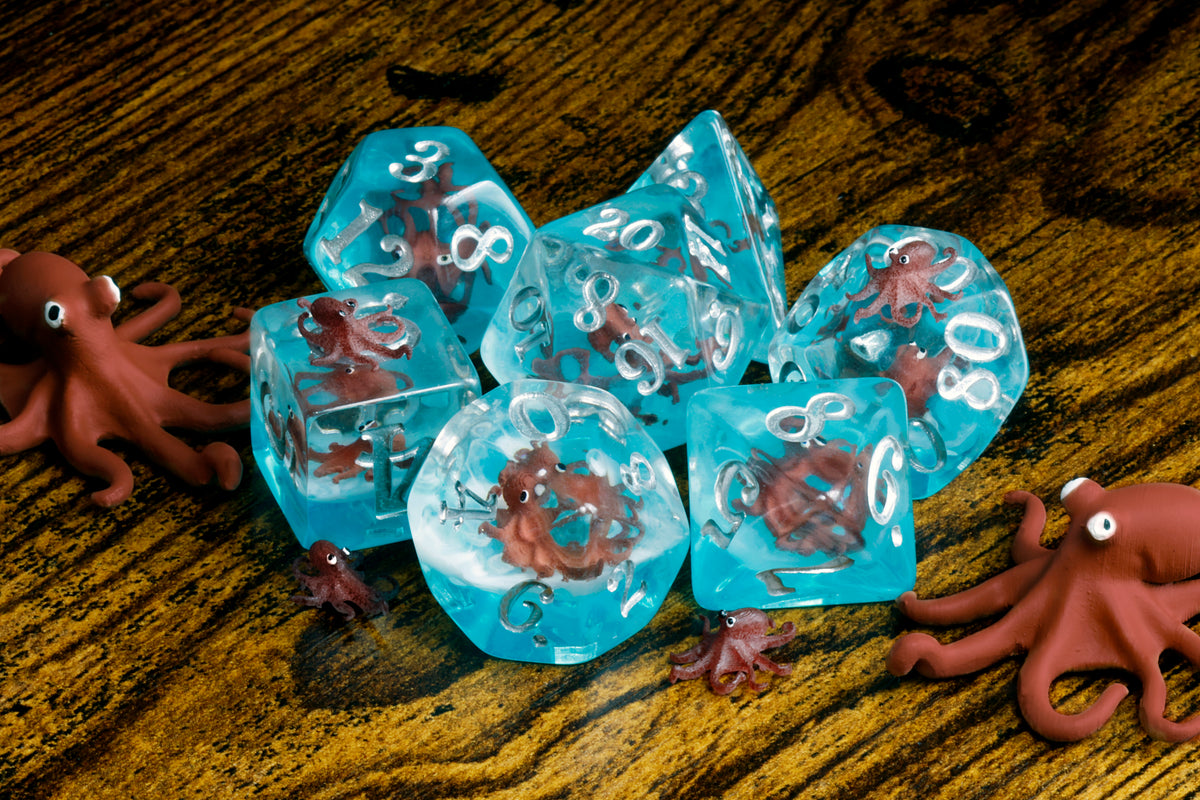 Octopus dice set with miniature octopus inclusions on a blue layer - The Wizard's Vault