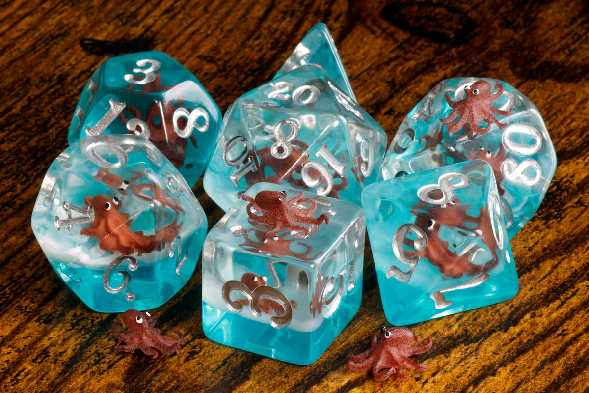 Octopus dice set with miniature octopus inclusions on a blue layer - The Wizard's Vault