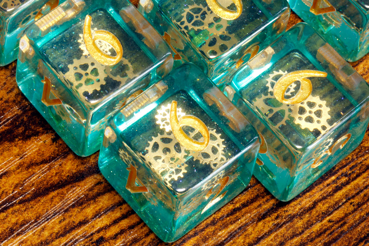 Ethereal Sprockets D6 Dice, Blue green glittery layer with small golden gear inclusions - The Wizard's Vault